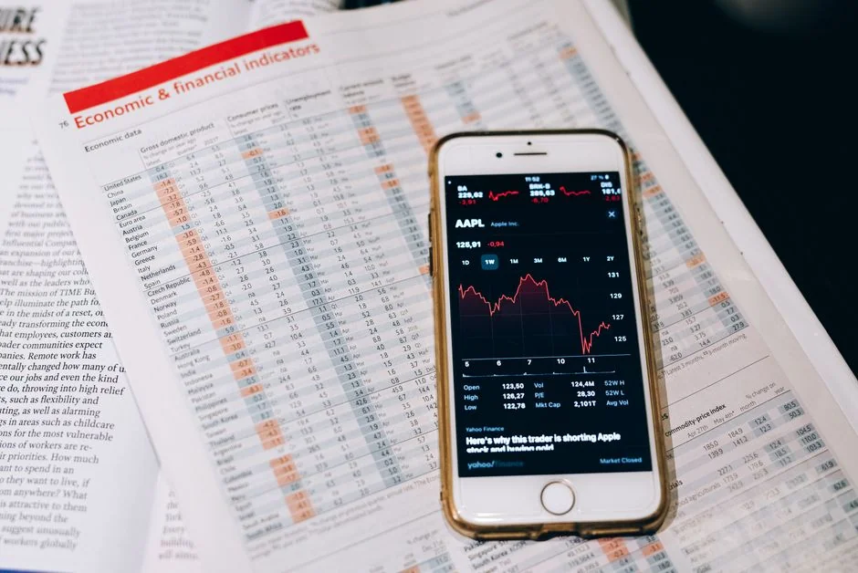 Équipe examinant des graphiques financiers et des données numériques sur des tablettes dans un bureau.